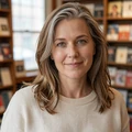 Amelia, a woman in her late forties with silver-streaked hair smiling in a Portland bookstore