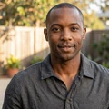 Marcus, a Black American man in his late thirties laughing in a sunlit Atlanta backyard