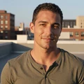 Daniel, a smiling man in his early thirties on a Chicago rooftop at sunset